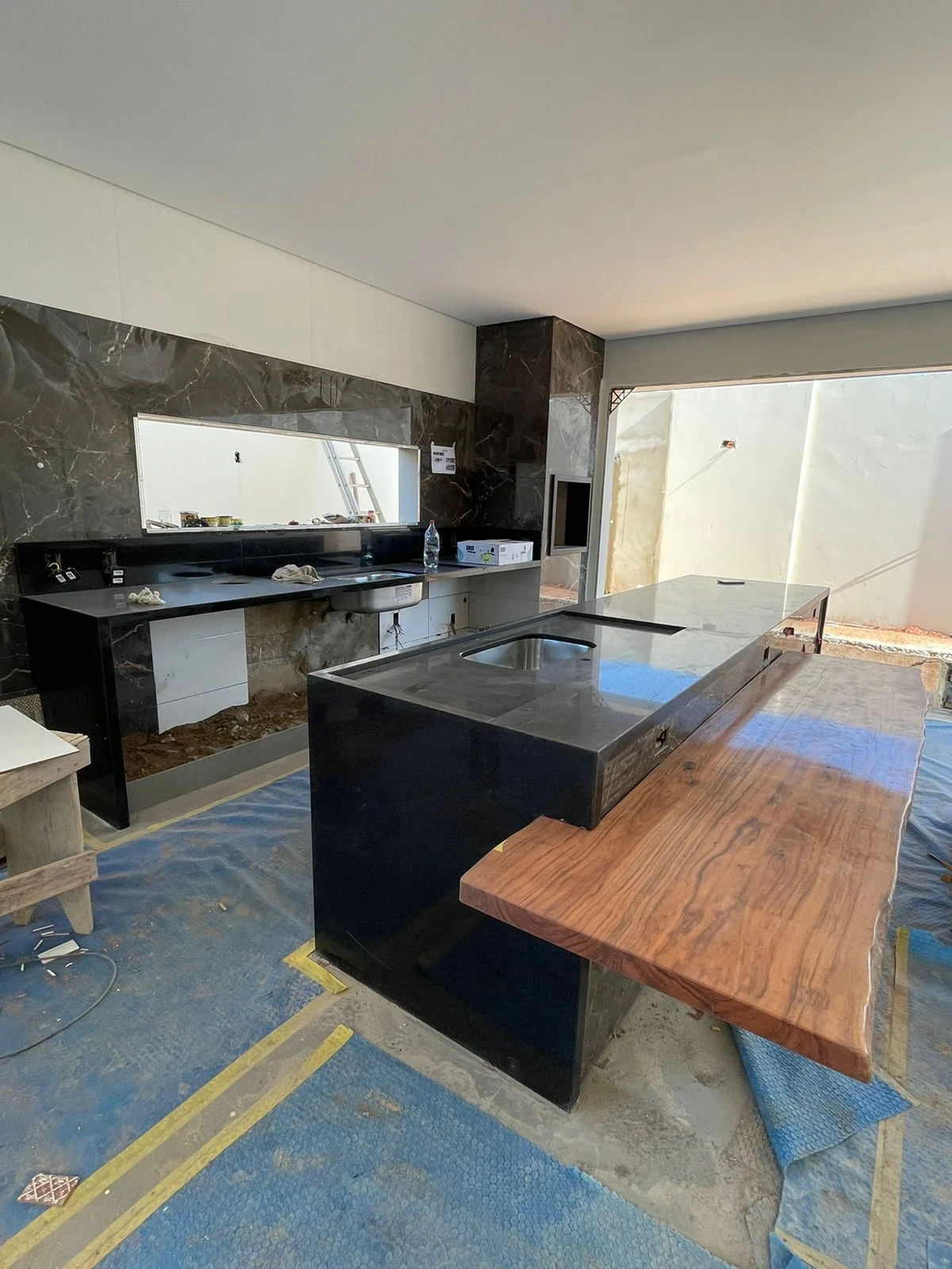 Ambiente residencial em fase de acabamento, com bancada e superfícies protegidas